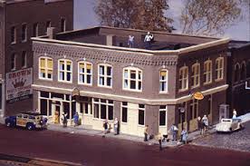 Walthers Merchant's Row III Item # 933-3064. In the early 20th century, successful merchants and speculators constructed commercial buildings like this in many parts of the Untied States. The ground floor was usually occupied by small businesses who used the large windows to display their wares. The upper floors might be sub-let as professional offices, a club meeting hall or converted to apartments. They can still be found on Main Street in small towns and big cities. Based on a prototype from eastern Ohio, this versatile structure comes with a set of plastic signs and colorful decals so it can be home to a variety of businesses in many eras. 6-1/4 x 7-3/4 x 4-3/4" (15-9/10 x 19-7/10 x 12cm)