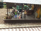 A steam locomotive passing a model town with period-accurate buildings and accessories.