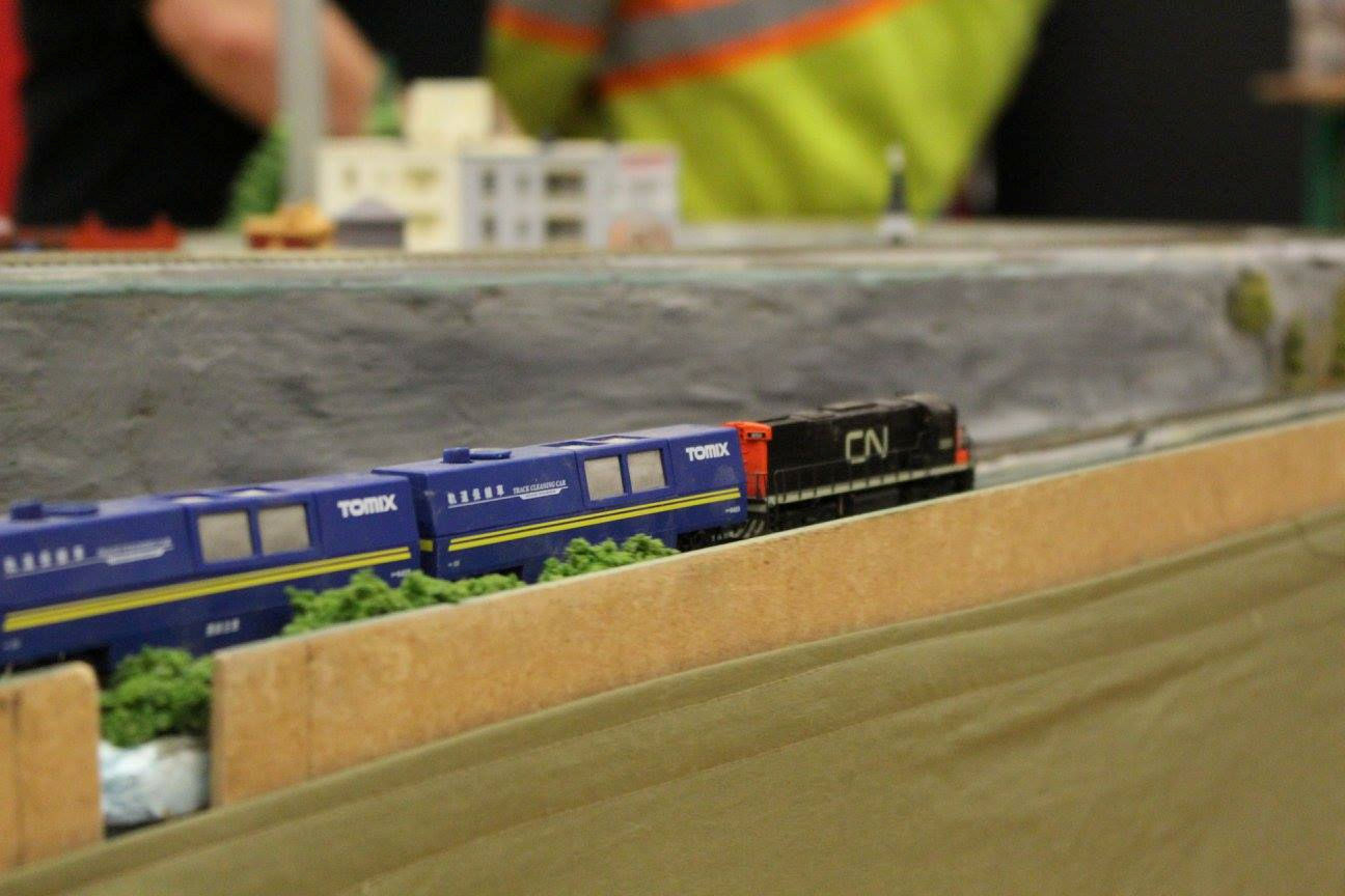 CN locomotive with Tomix track cleaning cars running on a model train layout.